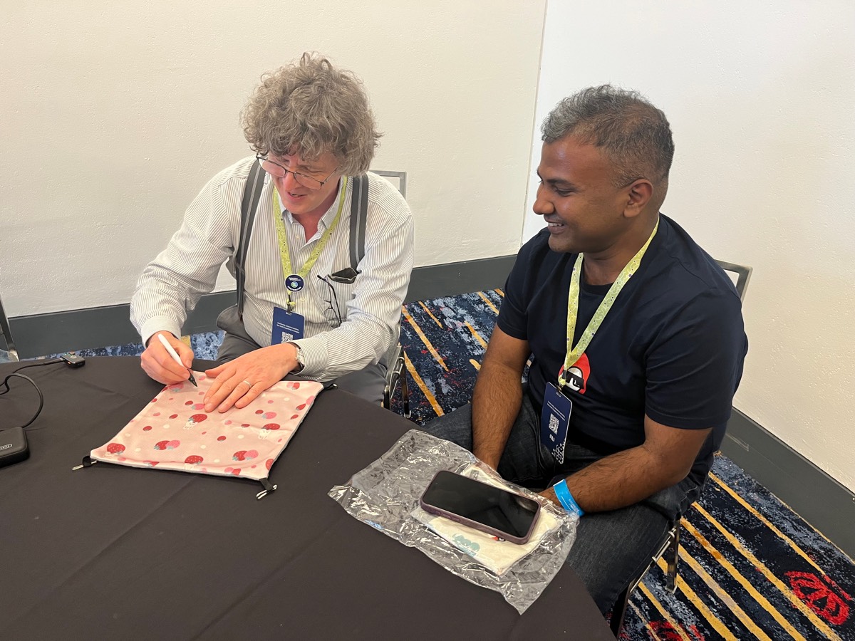 Rich Hickey and Rahul Dé getting his hamster hammock signed at Clojure/conj 2026